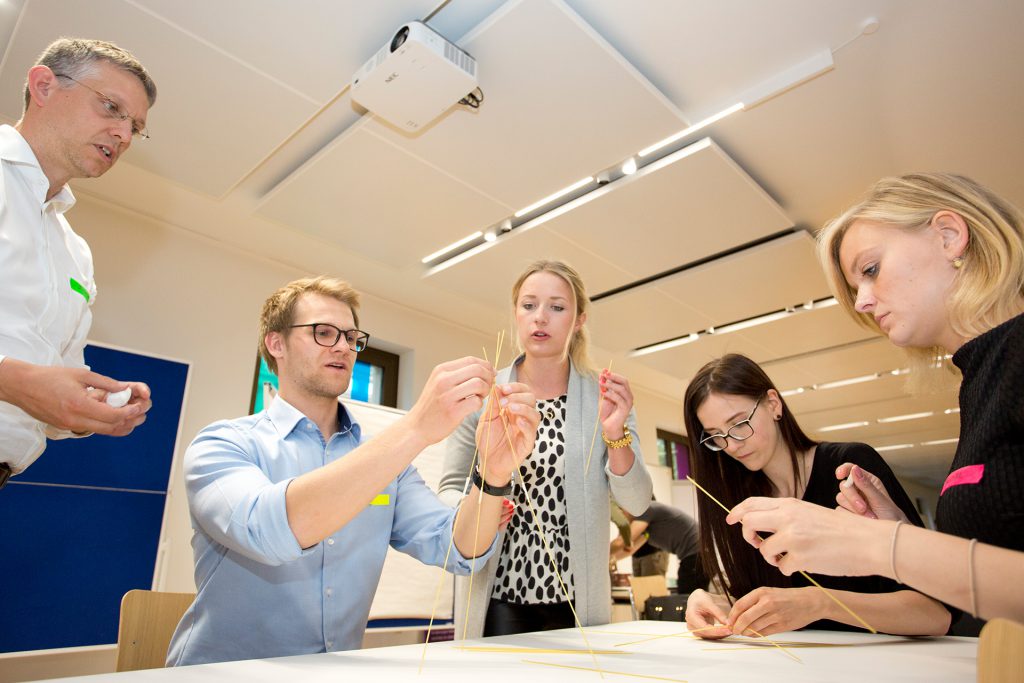 A group of people building a tower with sticks